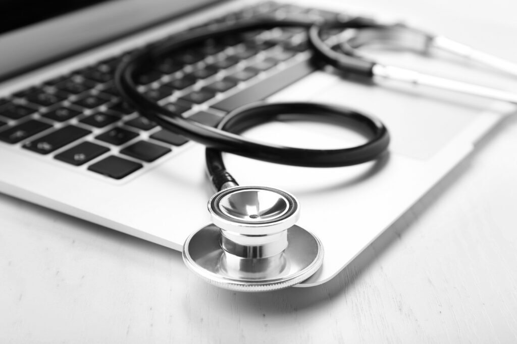 Estetoscópio apoiado sobre o teclado de um notebook, simbolizando a integração entre saúde, tecnologia e estratégias de marketing para clínicas e consultórios médicos.