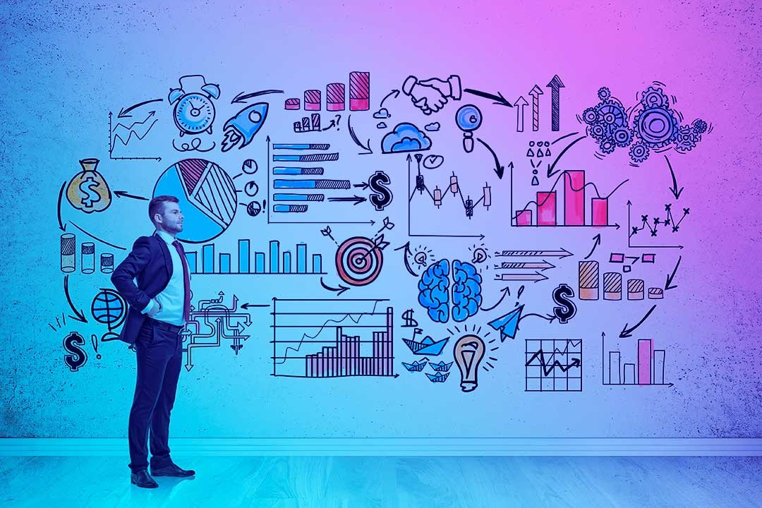 A imagem retrata um profissional de negócios, de terno, desenhando ou analisando um grande painel com diversos elementos visuais que representam estratégias e indicadores de performance.